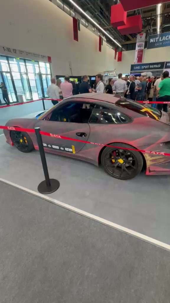 Ein Sportwagen auf einem Messestand in einer Ausstellungshalle.