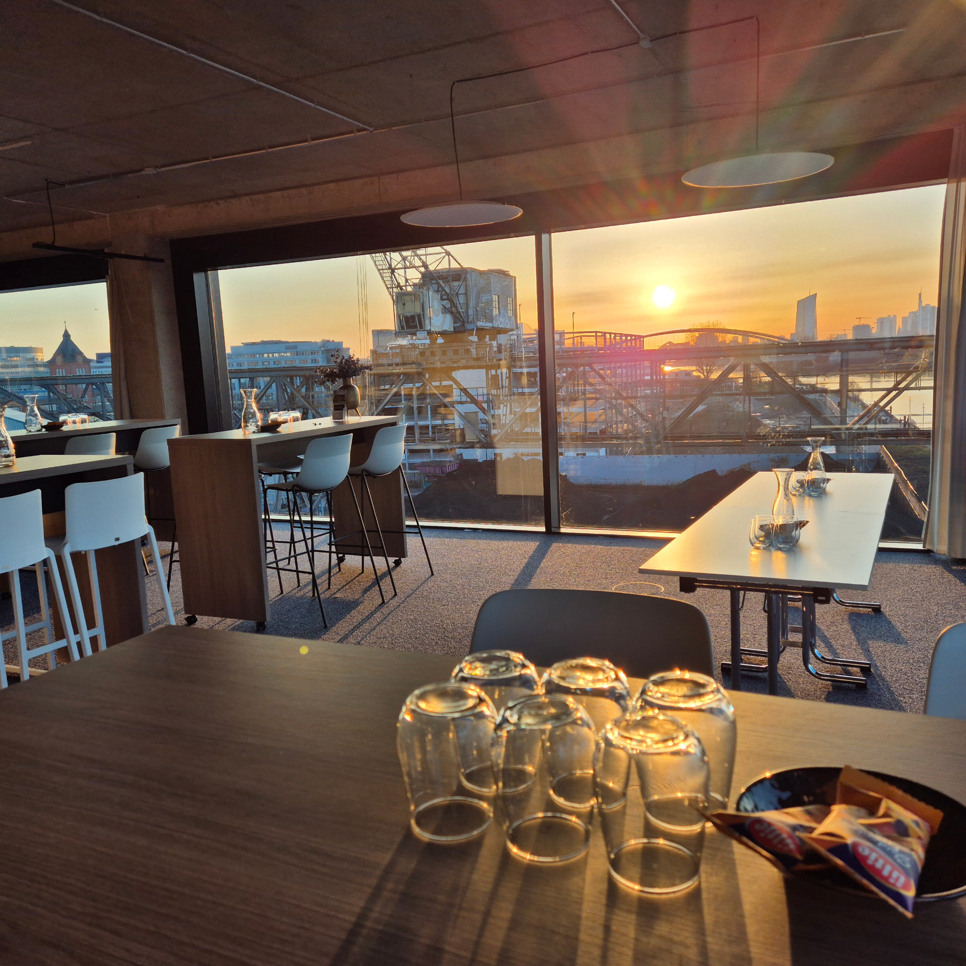 Loungebestuhlung im vierten Obergeschoss des Circle Cube bei Sonnenuntergang mit Blick auf die Frankfurter Skyline