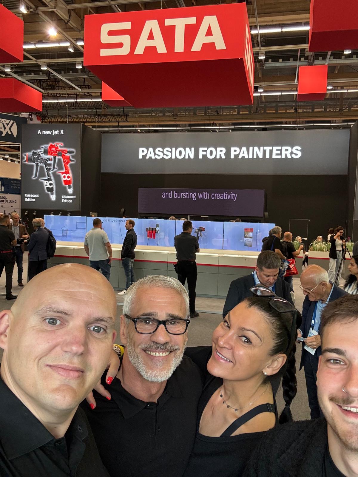 Mitarbeitende von Lofthouse Catering am Messestand vor einer roten SATA-Beschilderung.