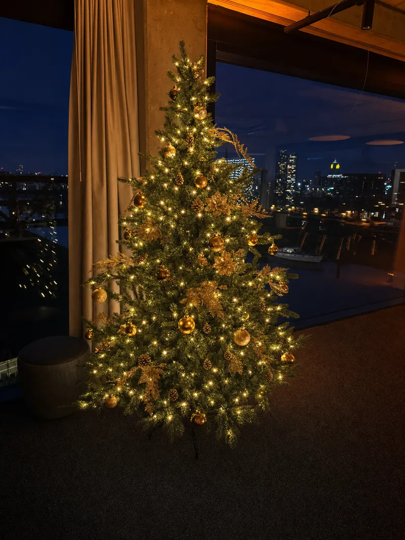 Geschmückter Weihnachtsbaum vor der nächtlichen Skyline